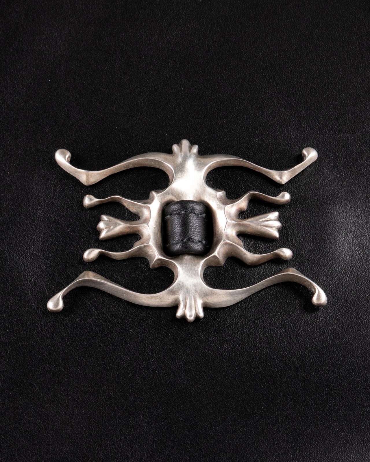 Silver ornament on black leather